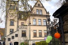 Fassade des historischen Gebäudes in Vorra, Luftballons am schmiedeeisernen Tor.